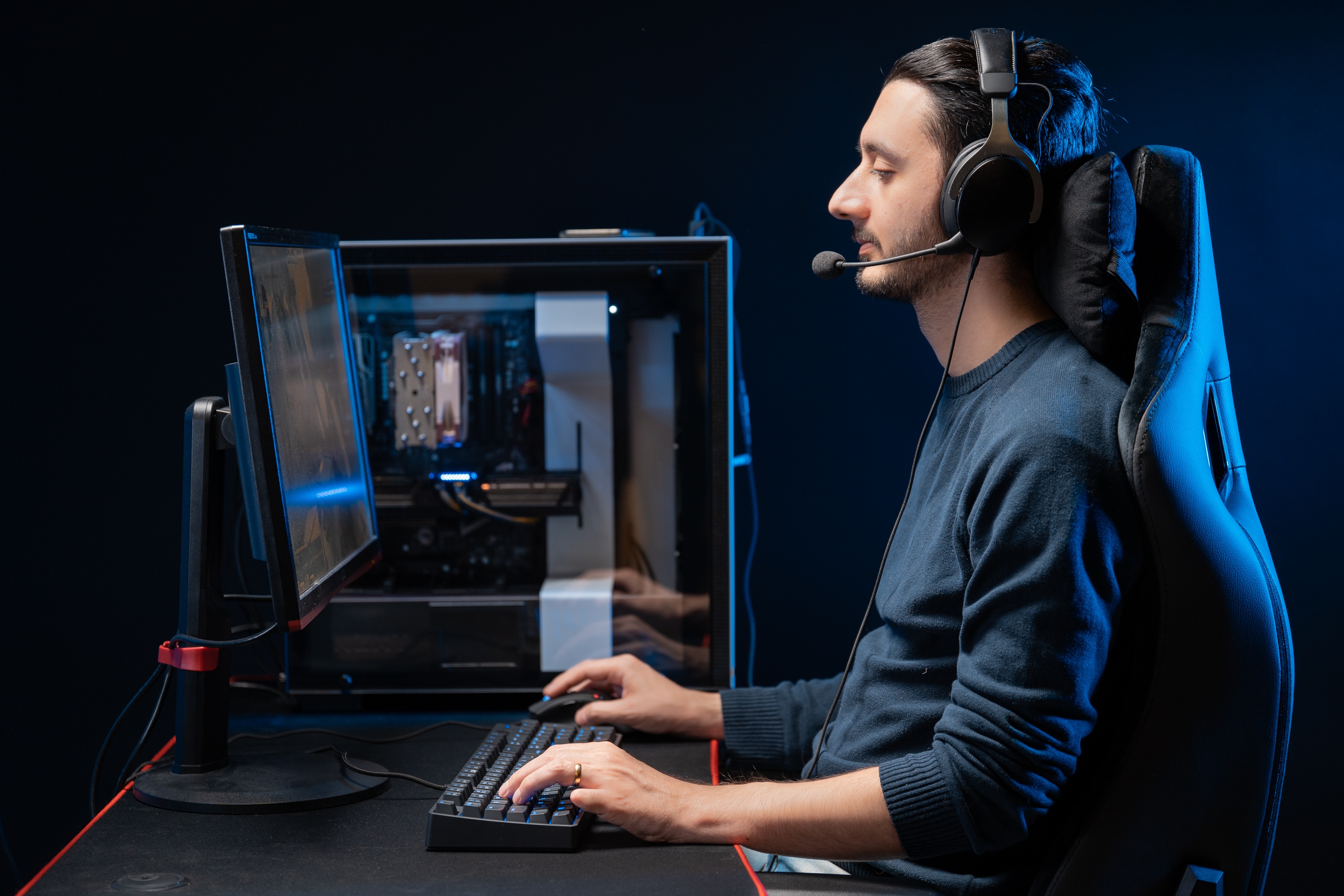 Ergonomisk riktig sittestilling: mann med headset sitter rett i ryggen og gamer